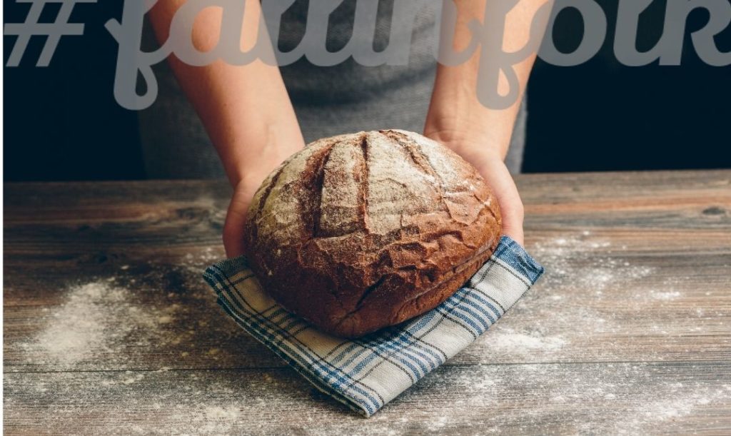 Folk to świeży chleb. Zdjęcie okrągłego chleba trzymanego na kraciastej chuście. Napis fallinfolk.