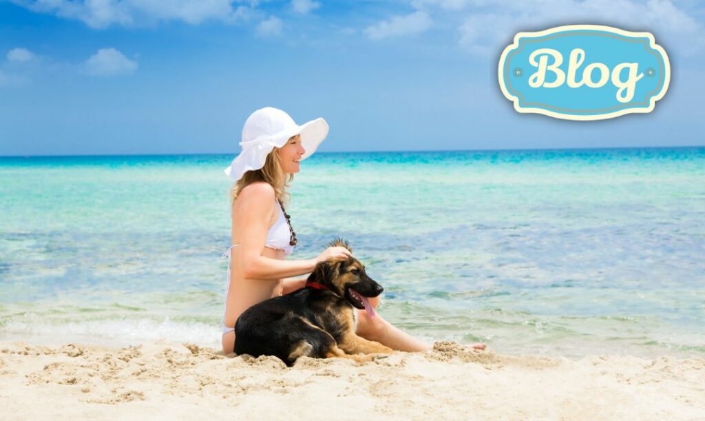 Niezapomniane chwile. Zdjęcie kobiety w białym bikini, białym kapeluszu na plaży, nad turkusową woda, siedzi z owczarkiem. Wszystko bardzo słoneczne. Logo Blog.